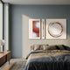 Virelium 3-Set Flame Gradient Double Ring I Acrylic 3D Wall Art by Giant Sculptures with red, orange, and brushed silver panels above a bed in a grey bedroom.