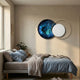 Auricara Sapphire White Disc & Metal Ring 3D Wall Art by Giant Sculptures, mounted above a bed with grey linen and blue pillows in a modern bedroom.