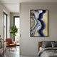 Veridra Golden Flight Acrylic & Metal 3D Wall Art by Giant Sculptures, with gold birds, navy and beige waves, displayed in a bedroom beside a rust armchair.