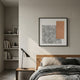 Terracube II Hand-Painted Framed Acrylic 3D Wall Art by Giant Sculptures, with grey brushstroke panel and peach cube grid, hung above a wooden bed in a modern bedroom.