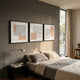 Terracube 3-Set Hand-Painted Framed Acrylic 3D Wall Art by Giant Sculptures displayed above a bed with grey linen bedding, beside a black nightstand and window.