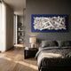 Stravira Blue I Sculptural White Metal 3D Wall Art by Giant Sculptures, white iron lattice on a blue panel, mounted above a bed in a modern bedroom.