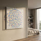 Haliora Iridescent Shard Circular Acrylic 3D Wall Art by Giant Sculptures displayed on a beige wall in a modern bedroom with oak floors and shelving.