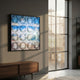 Seavista Cloudline Blue Horizon Acrylic Dome 3D Wall Art mounted on a grey wall above a walnut sideboard beside a tall sunlit window in a modern room.