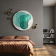 Cirelo Teal & Mint Disc Acrylic 3D Wall Art mounted above a bed with brown linen, paired with clustered gold metal balls on a grey bedroom wall.