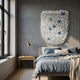 Papillara Blue Butterfly Feathered Acrylic 3D Wall Art by Giant Sculptures mounted above a bed with blue linens, beside a window and wooden nightstand.