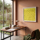 Frondra Yellow Layered Leather 3D Wall Art by Giant Sculptures displayed in a peach-toned home office above a wooden desk with books, lamp, and laptop.