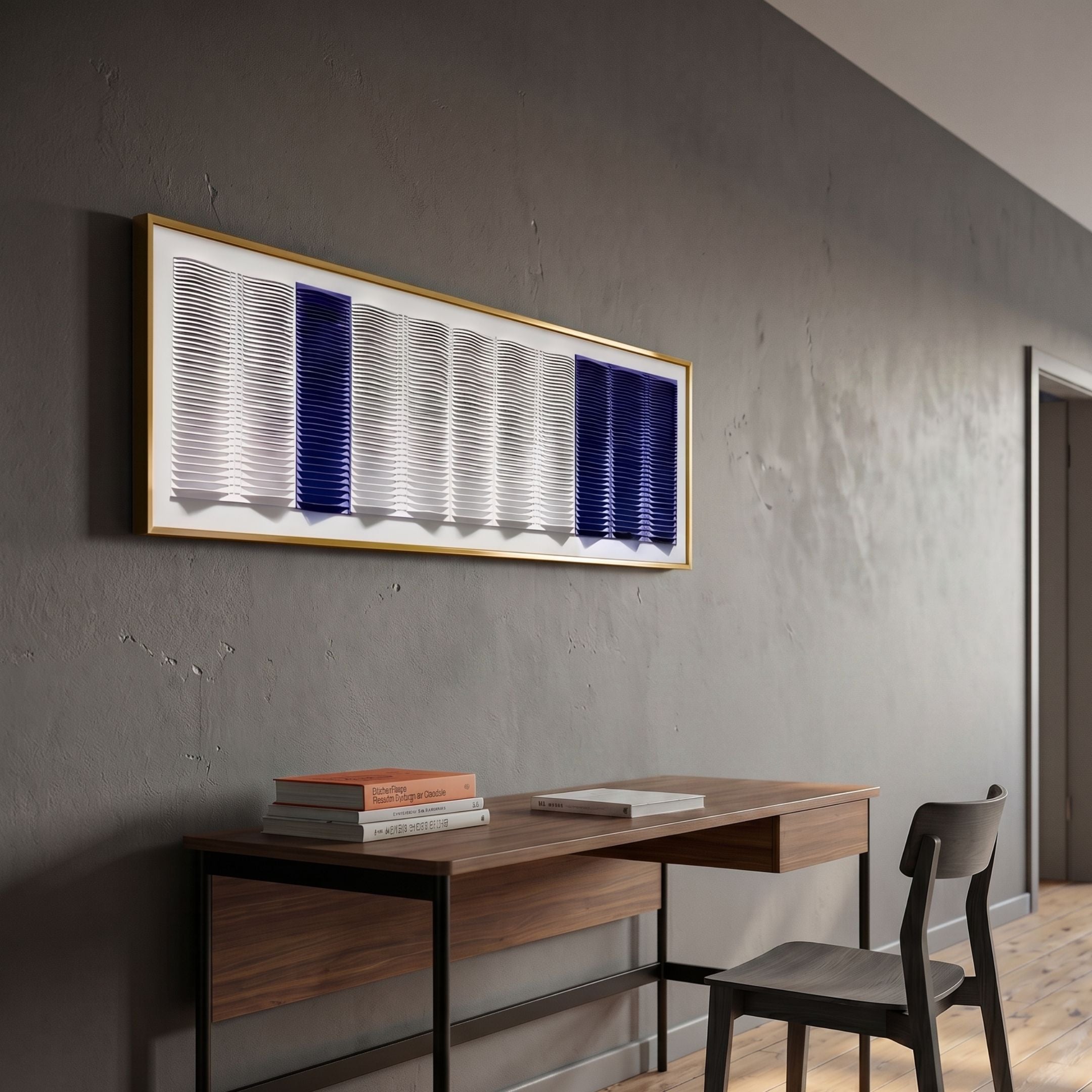 Striara White & Cobalt Flow Stripe Acrylic 3D Wall Art by Giant Sculptures in a gold frame, mounted on a grey wall above a wooden desk and chair.