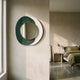 Solistra Emerald II Layered Round Mirror 3D Wall Art by Giant Sculptures, gold-framed circular mirror on emerald and white layered discs, mounted in a sunlit bedroom.