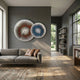 Lustara Blue & Copper Dual Circular Leather 3D Wall Art by Giant Sculptures displayed on a grey wall above a taupe sofa with brown leather cushions.