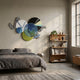 Cinetta Green & Blue Geometric Wood Carved 3D Wall Art by Giant Sculptures displayed above a grey linen bed in a modern bedroom beside a wooden bookshelf.
