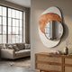 Solistra Amber III Layered Round Mirror 3D Wall Art with gold-framed round mirror and white and rust-orange shapes, hung above a cane sideboard in a living room.