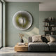 Lustara Yellow Gradient Circular Leather 3D Wall Art mounted on a sage green wall above a grey sofa and wooden coffee table in a modern living room.