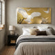 Aurellion White Birds Flight Gold Panel 3D Button Wall Art by Giant Sculptures displayed above a neutral-toned bed, showing raised white birds in flight on a warm gold background with a dark branch detail.