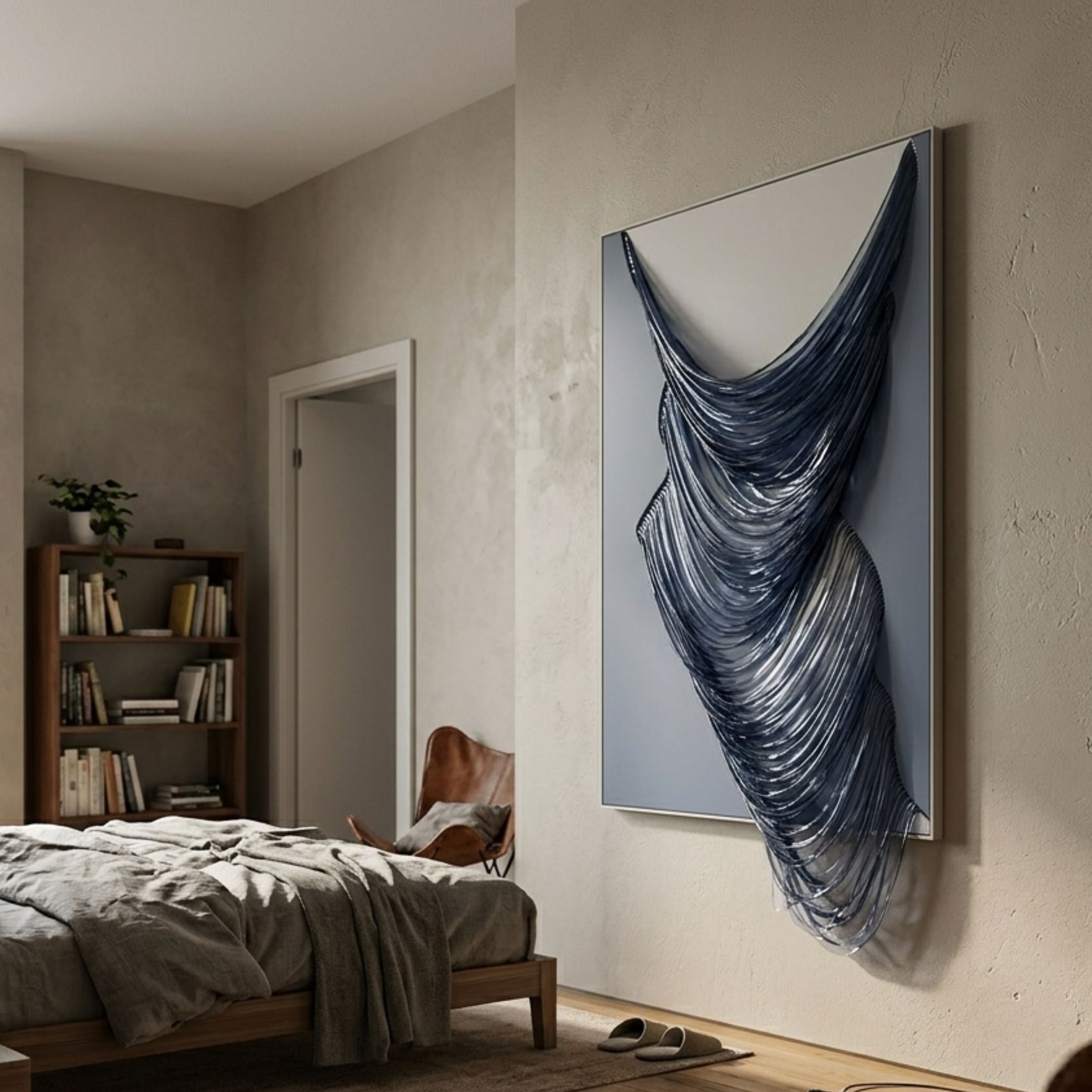 Arvinea Blue Flow Sculptural Leather 3D Wall Art by Giant Sculptures, with cascading navy and frost white leather strips, displayed on a bedroom wall beside a leather chair.