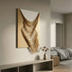Arvinea Gold Flow Sculptural Leather 3D Wall Art with cascading golden waves on a gold and white panel, mounted above a console in a bedroom.