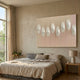 Virello Soft Blush & White Disc Leather 3D Wall Art by Giant Sculptures displayed above a linen-dressed bed in a sunlit neutral bedroom with side lamp.