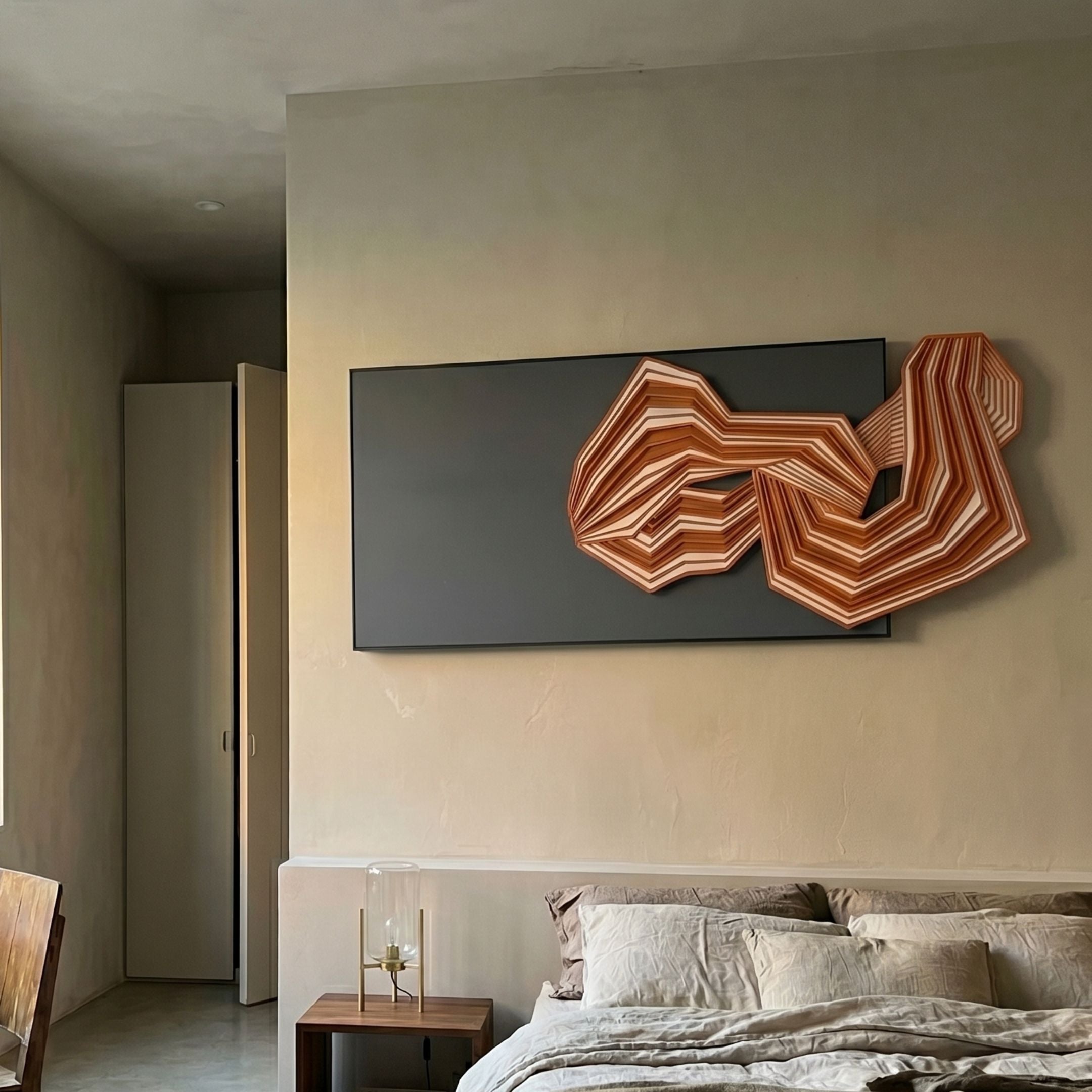 Riborra Black & Warm Red Layered Wood Carving 3D Wall Art mounted above a linen-dressed bed with a bedside lamp in a neutral-toned bedroom.