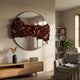 Stravelle Amber & Black Fold Leather Mirror 3D Wall Art by Giant Sculptures mounted above a wooden console in a warm living room with armchair and bookshelf.
