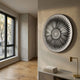 Centriva Cream II Folded Leather Round 3D Wall Art by Giant Sculptures mounted on a beige wall above a console with brass lamp in a sunlit hallway.