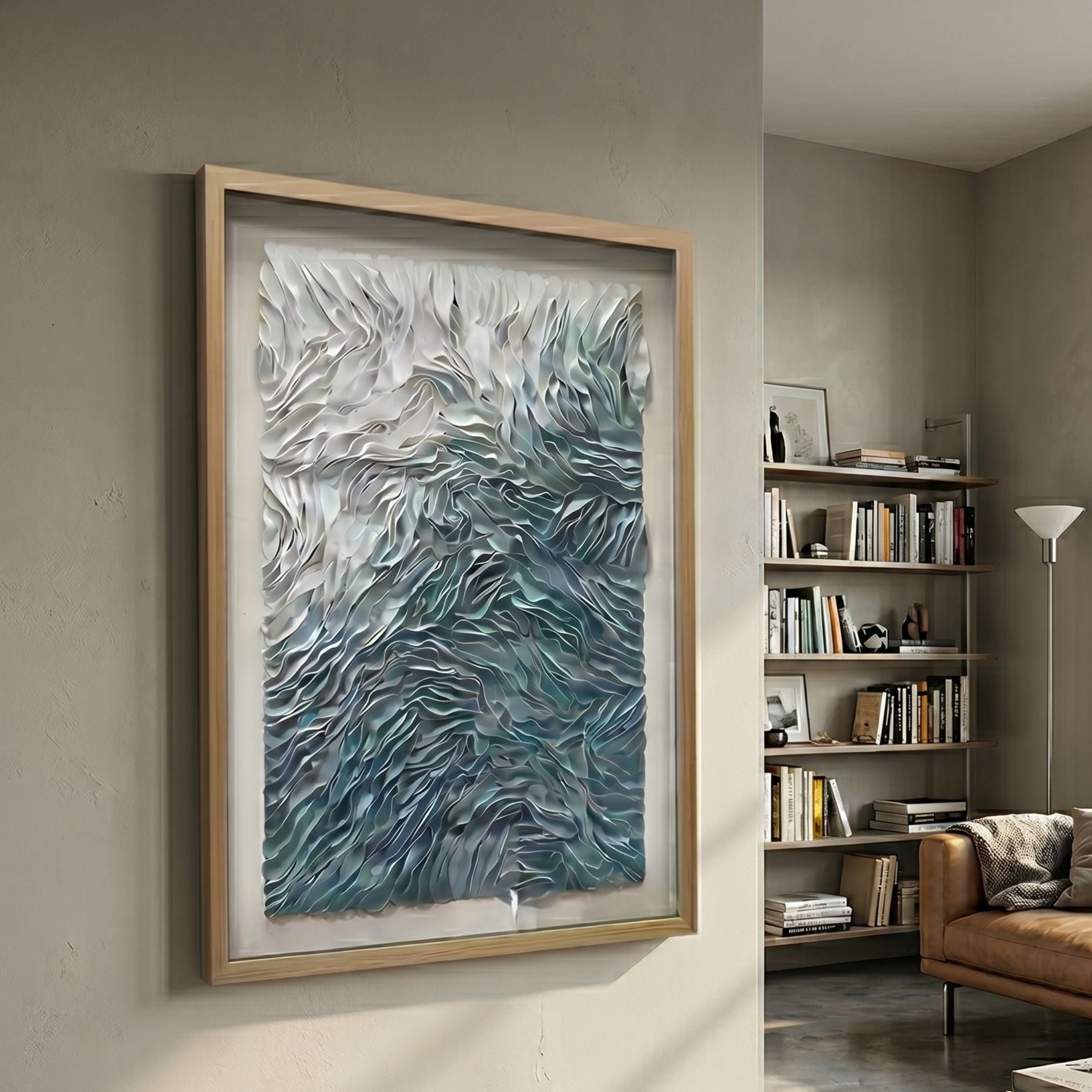 Florasca Blue Ripple Leather 3D Framed Wall Art in a light wood frame, displayed on a beige living room wall beside a bookshelf and tan sofa.