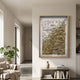 Florasca Gold Ripple Leather 3D Framed Wall Art by Giant Sculptures displayed in a neutral living room above a console with vase and books, beside a monstera plant.