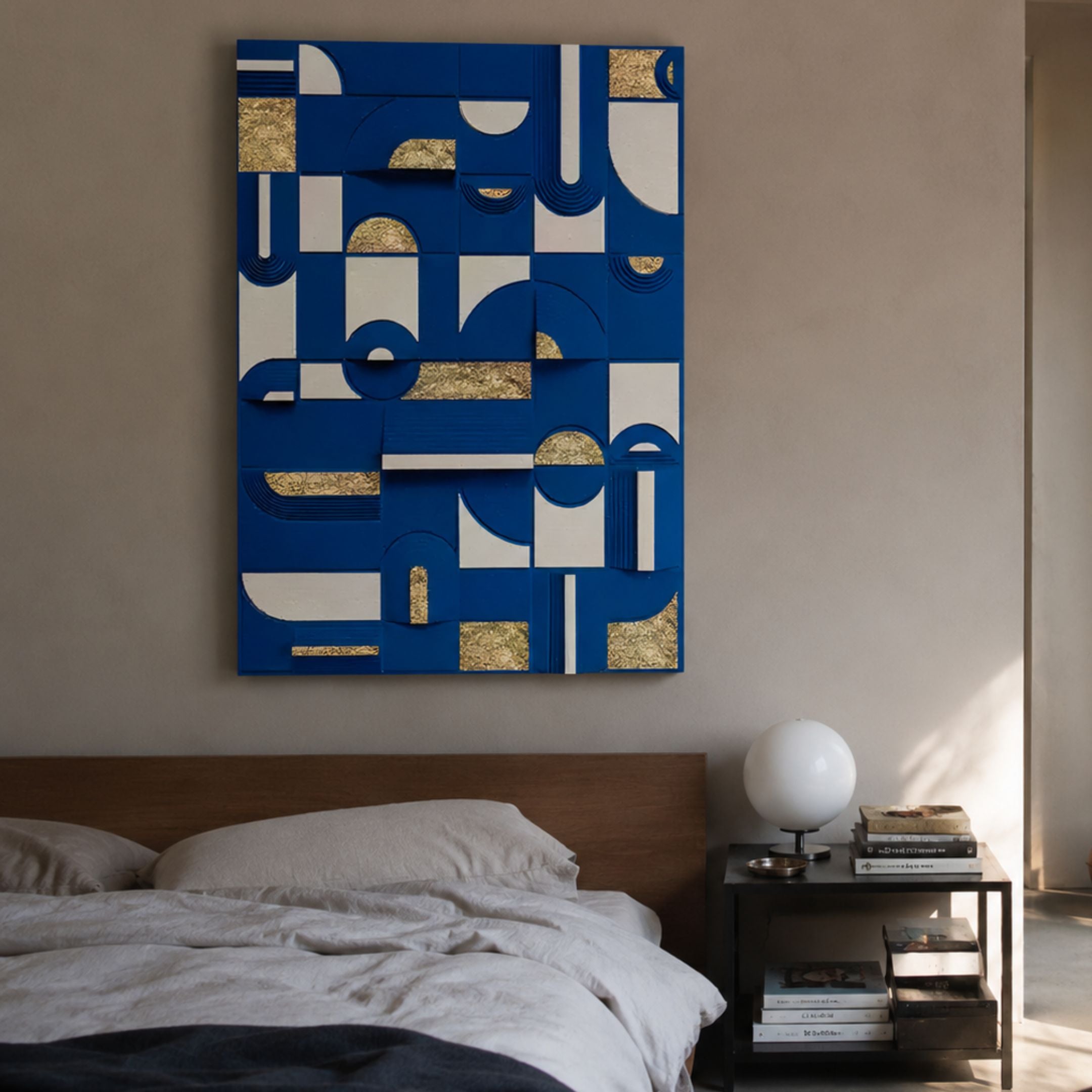 Moduvo Gold Accent Blue 3D Carving Wall Art by Giant Sculptures mounted above a wooden bed, with a globe lamp and stacked books on the bedside table.