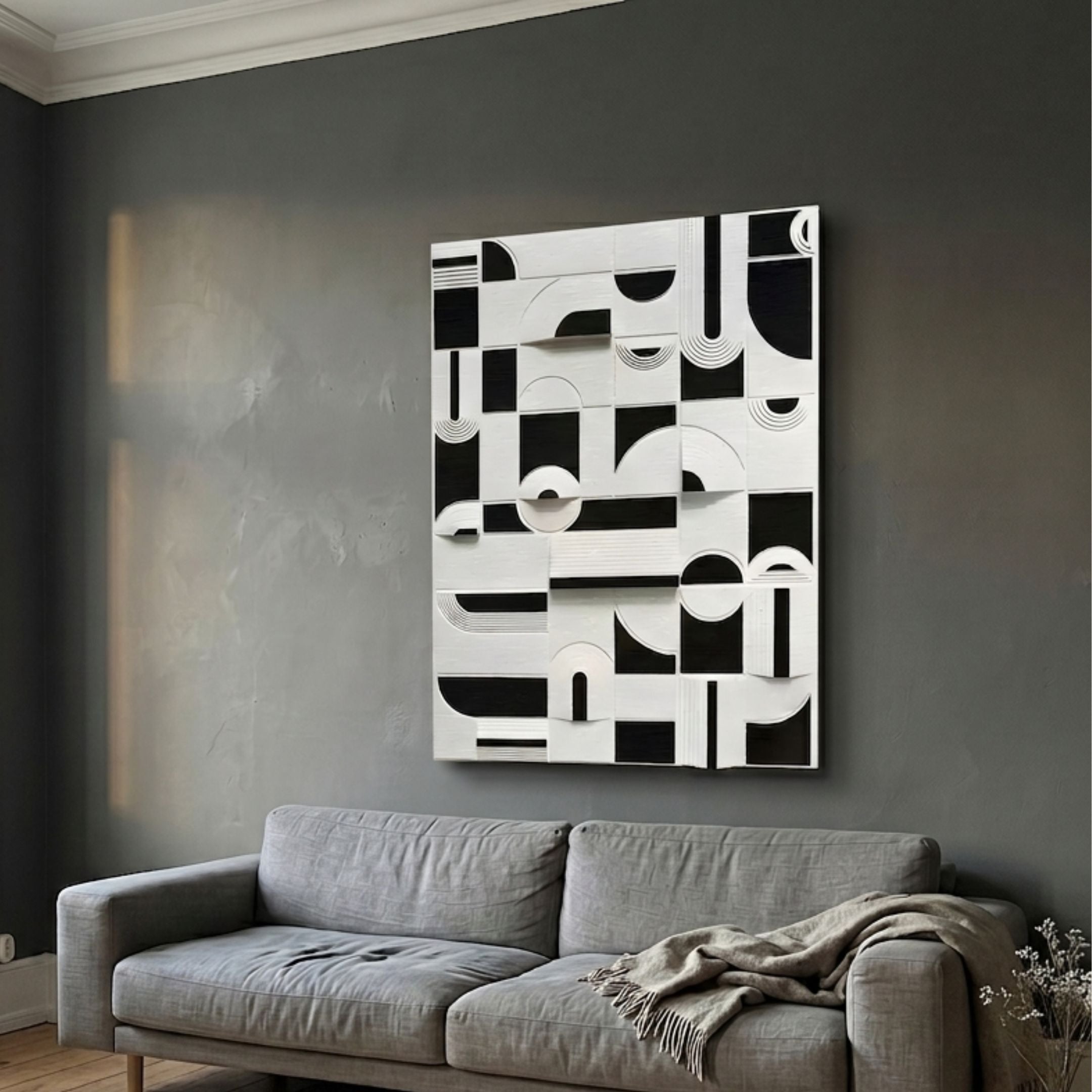 Moduvo Black & White Geometric 3D Carving Wall Art mounted above a grey linen sofa in a dark grey living room, showing carved arcs, rectangles, and lines.