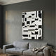 Moduvo Black & White Geometric 3D Carving Wall Art mounted above a grey linen sofa in a dark grey living room, showing carved arcs, rectangles, and lines.