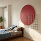 Orivis Crimson Disc Metal Grid 3D Wall Art by Giant Sculptures mounted above a wooden bed with linen bedding, beside a fiddle-leaf fig in a sunlit bedroom.
