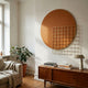 Orivis Amber Disc Metal Grid 3D Wall Art by Giant Sculptures displayed above a wooden sideboard in a sunlit living room with a potted plant and linen sofa.