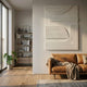 Lineaform Layered Flow Wood Carving 3D Wall Art in white displayed above a tan leather sofa in a Nordic living room with bookshelf and monstera plant.