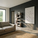 Cavara Foliage Textured White 3D Relief Wall Art by Giant Sculptures mounted on a dark grey wall in a modern living room with a beige sofa and bookshelf.