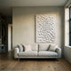 Cavara Echo Textured White 3D Relief Wall Art by Giant Sculptures, mounted above a beige linen sofa in a minimalist living room with wood flooring.