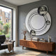 Astryn Chrome Orbit Round Textured 3D Wall Art by Giant Sculptures displayed on a grey wall above a walnut sideboard in a modern living room with armchair.
