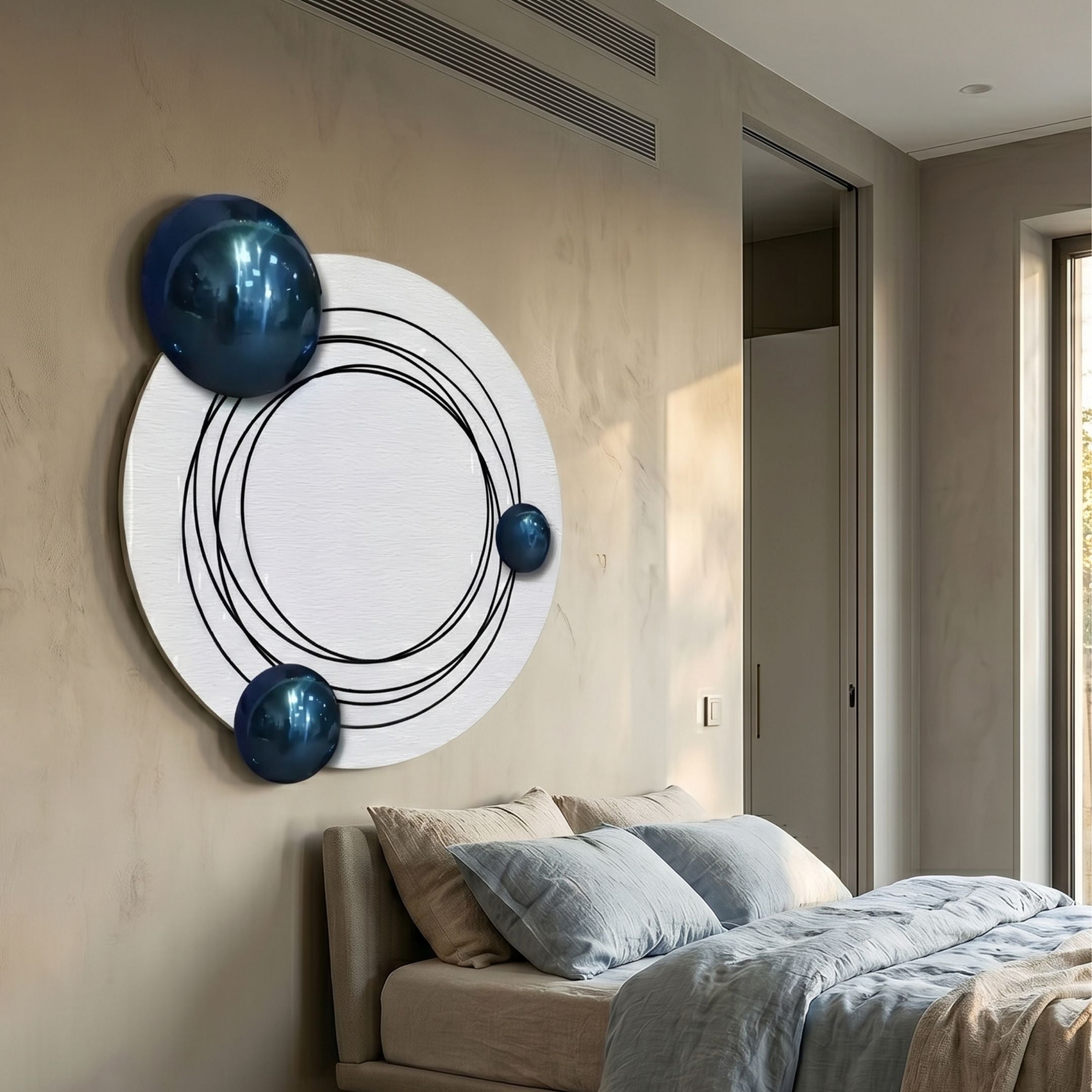 Astryn Blue Orbit Round Textured 3D Wall Art by Giant Sculptures, white sandstone disc with black concentric rings and three blue spheres, mounted above a bed.