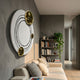 Astryn Gold Orbit Round Textured 3D Wall Art by Giant Sculptures displayed above a beige sofa in a modern living room with bookshelf and trailing plant.