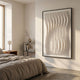 Velistra Vertical Ripple 3D Relief Wall Art by Giant Sculptures, a large white block-grid panel in a black frame, displayed in a minimalist bedroom beside a linen-dressed bed.