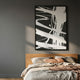 Deralin Charcoal Flow Abstract 3D Carving Wall Art with white carved linework on charcoal sandstone, framed in black above a wood-headboard bed.