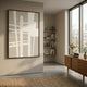 Giant Sculptures Deralin Taupe Grid Abstract 3D Carving Wall Art in a black frame, displayed on a beige wall in a sunlit modern living room with shelves.