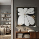Petala Black & White Bloom Wood Relief 3D Wall Art by Giant Sculptures displayed on a grey living room wall above a walnut console with books and a vase.