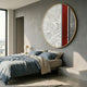 Orizon Urban Trace Round 3D Carving Wall Art by Giant Sculptures mounted above a bed with blue linen bedding in a sunlit grey concrete bedroom.