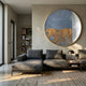 Orizon Azure & Brass Layered Round 3D Carving Wall Art by Giant Sculptures, mounted above a grey sectional sofa in a modern living room with bookshelf.