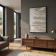 Deralin Taupe Drift Abstract 3D Carving Wall Art in a black frame above a walnut sideboard with vase and books in a modern grey-walled living room.