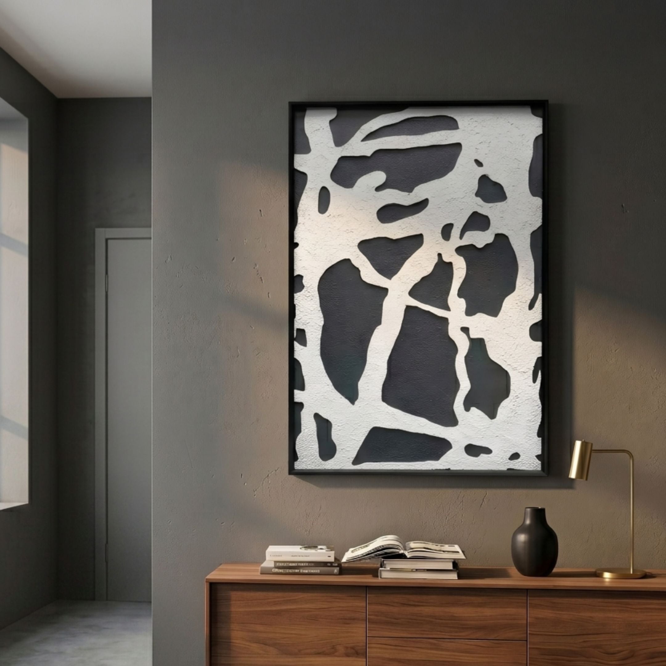 Drosan Midnight Trace II Wood Carving 3D Wall Art in a black frame on a grey wall above a walnut sideboard with books, a vase, and brass lamp.