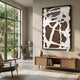 Drosan Earth Trace II Wood Carving 3D Wall Art in a black frame, displayed above a cane sideboard in a sunlit modern living room with garden views.