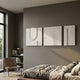 Moro II Triptych White Relief 3D Wall Art by Giant Sculptures displayed above a linen-dressed bed in a warm grey bedroom with a leather chair and bookshelf nearby.