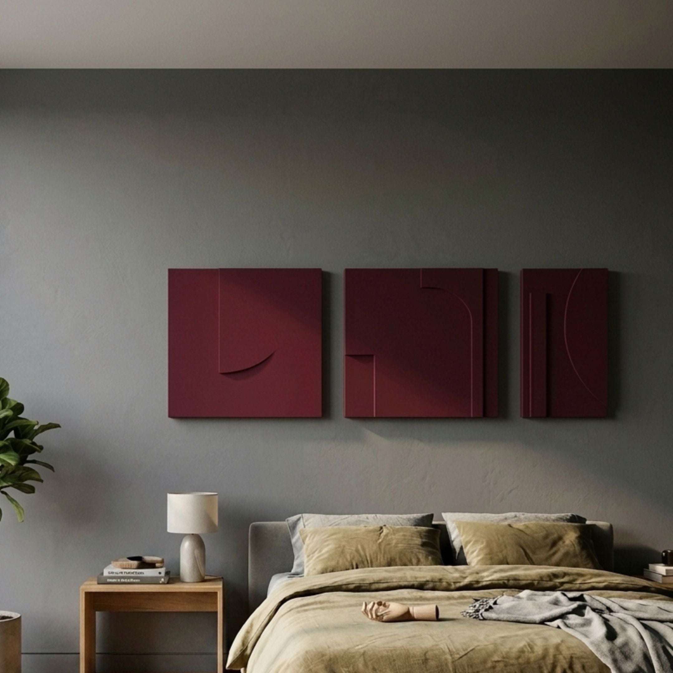 Moro II Triptych Deep Red Relief 3D Wall Art by Giant Sculptures in matte burgundy sandstone, mounted above a bed with olive linen in a grey bedroom.