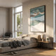 Skymelt Blue Hand-Painted Sandstone 3D Wall Art displayed above a low beige bed in a sunlit modern bedroom with a grey armchair and wooden side table.