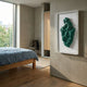Malachra Crest I Relief Sandstone 3D Wall Art by Giant Sculptures mounted in a modern bedroom with a blue linen bed, oak frame, and large window.